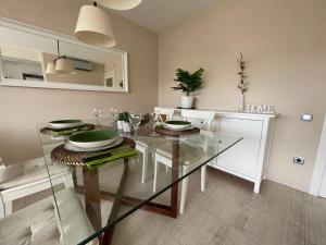 un comedor con una mesa de cristal con platos. en A 600 metros de la playa, ideal para familias, en S'Agaró