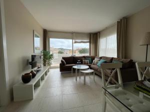 a living room with a couch and a table at A 600 metros de la playa, ideal para familias in S'agaro