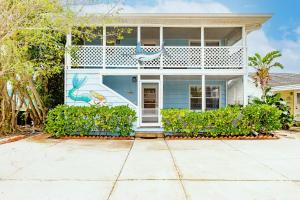 a white house with a balcony and a driveway at Siesta Key Island Rentals in Siesta Key