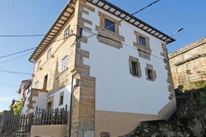 un edificio blanco con una valla negra en LA MAR SALADA, en Lastres