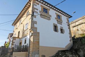a white building with a black fence at LA MAR SALADA in Lastres