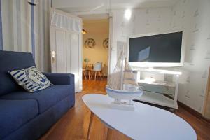 a living room with a blue couch and a tv at LA MAR SALADA in Lastres