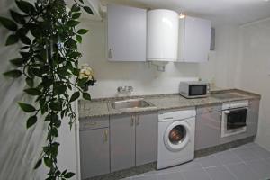 a kitchen with a sink and a washing machine at LA MAR SALADA in Lastres