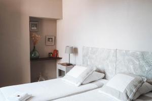 een slaapkamer met een bed met witte lakens en kussens bij Maison d'Hotes Delga in Gaillac