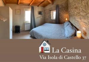 a bedroom with a bed and a stone wall at La casina in Sonnino