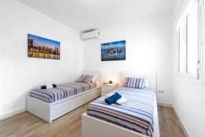 two beds in a room with white walls at La Casa del Campo de Mis Rapaciños in Alhaurín el Grande +22 photos