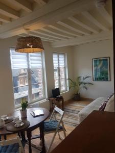 sala de estar con mesa y 2 ventanas en LE PETIT MATELOT, en Honfleur