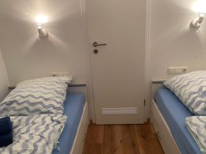 2 camas en una habitación con 2 luces en la pared en Appartement mit Balkon und Meerblick, en Fehmarn