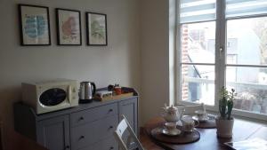 a room with a table with a microwave and a window at LE PETIT MATELOT in Honfleur +5 photos