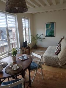 a living room with a table and a couch at LE PETIT MATELOT in Honfleur