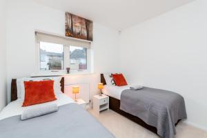 1 dormitorio con 2 camas y ventana en Lovely 2-Bed Apartment in Dartford en Dartford