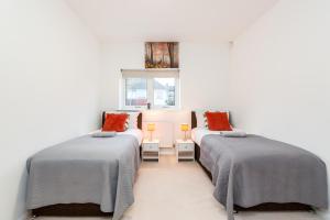 ダートフォードにある2BR Apt-Sleeps 5-Accessible-Central Dartfordの白い壁の部屋にベッドが2つある