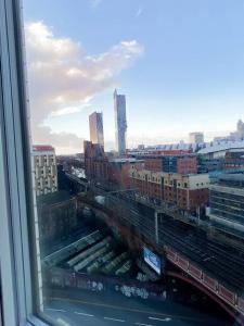 una ventana con vistas a una ciudad con vías de tren en The Panda - Modern 2 Bedroom Apt in Manchester City Centre, en Mánchester