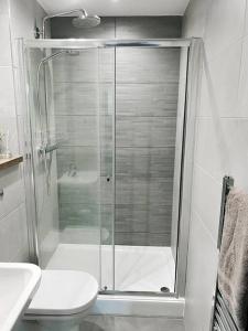 een badkamer met een douche, een toilet en een wastafel bij The Panda - Modern 2 Bedroom Apt in Manchester City Centre in Manchester