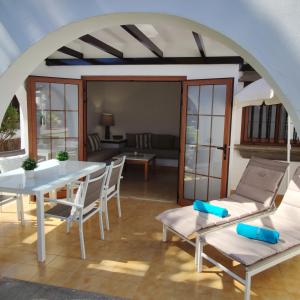 een woonkamer met een witte tafel en stoelen bij Bungalow Parque Golf by SunHousesCanarias in Maspalomas