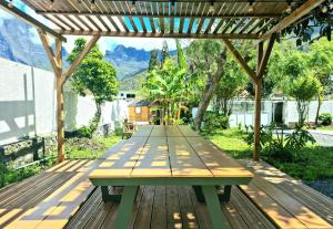 a picnic table on a wooden deck with a pergola at Le vieux clocher in Cilaos