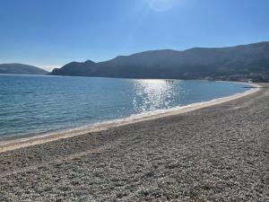 a beach with water and mountains in the background at Apartments Luna in Baška
