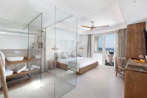 a bedroom with a bed and a glass wall at Maya Beach Resort in Massa Lubrense