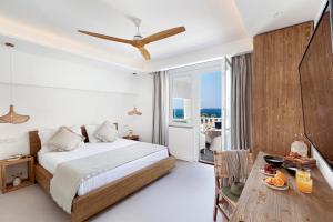 a bedroom with a bed and a table and a balcony at Maya Beach Resort in Massa Lubrense