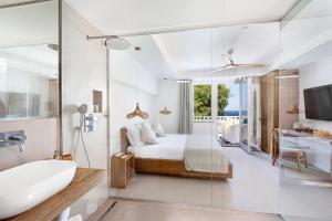 a bathroom with a bed and a tub and a sink at Maya Beach Resort in Massa Lubrense