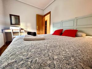 een slaapkamer met een groot bed met rode kussens bij Balcón con Vistas a la Catedral de Burgos- ATUAIRE- in Burgos