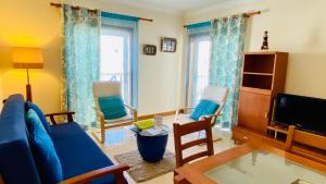 - un salon avec un canapé bleu et des chaises dans l'établissement Old Town by Check-in Portugal, à Albufeira