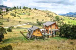 a small house in a field with a hill at Refugio entre el cielo in Guatavita