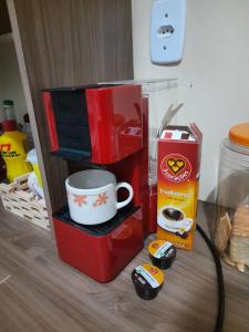 a table with a microwave and a coffee cup and controllers at Linda casa com 2 quartos, um com ar e outro com ventilador, e garagem in Parnaíba