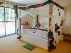 una camera con un grande letto a baldacchino di Tropicana Garden a Kendwa