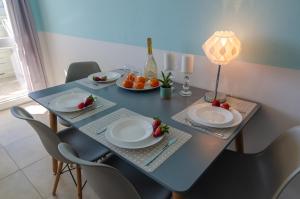 a blue table with plates and fruit on it at Holiday Home Slavia New 810 z widokiem na morze in Międzyzdroje