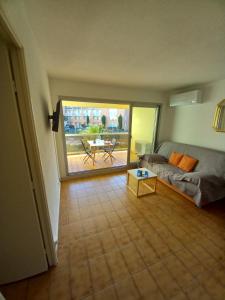 sala de estar con sofá y mesa en Hélios 24, T2 climatisé, parking, terrasse, 500m plage en Cap d'Agde