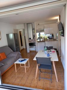 uma sala de estar com um sofá e uma mesa em Hélios 24, T2 climatisé, parking, terrasse, 500m plage em Cap d'Agde