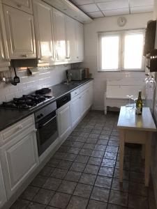 een keuken met witte kasten, een fornuis en een tafel bij 't Molentje in Zandvoort