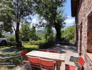 a wooden table and chairs sitting next to a building at Can Simonet de Rocabruna in Rocabruna