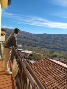 a man standing on a balcony looking at the mountains at La Lancha in El Torno