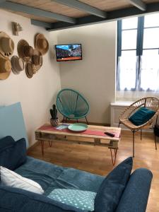 ein Wohnzimmer mit einem Sofa und einem Tisch in der Unterkunft Maison de pêcheur située dans une impasse privée à 300 m de la mer in Les Sables-dʼOlonne