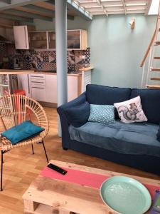 ein Wohnzimmer mit einem blauen Sofa und einem Tisch in der Unterkunft Maison de pêcheur située dans une impasse privée à 300 m de la mer in Les Sables-dʼOlonne