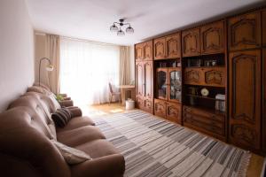 a living room with a brown couch and a table at 21 Cozy Apartament in Bistriţa