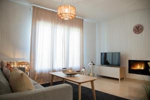 a living room with a couch and a tv and a table at Apartament La Cabanera in Sort