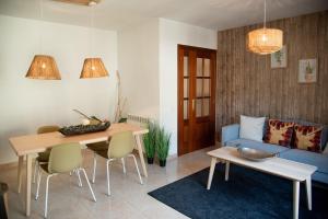 un soggiorno con tavolo e divano blu di Apartament La Cabanera a Sort