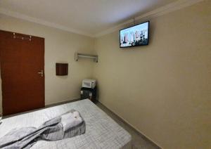 sypialnia z łóżkiem z telewizorem na ścianie w obiekcie Residencial Vila Buarque w São Paulo