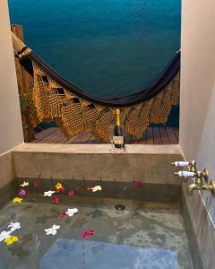 a room with a bathtub with flowers in the water at Tropicália chalés boutique in Pipa