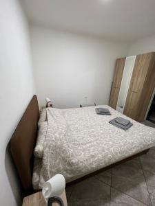 a bed in a room with a white bedspread at Aurora apartment in Sombor