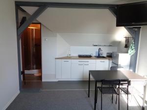 a kitchen with white cabinets and a table and chairs at Apartamenty Wyspiańskiego in Świnoujście