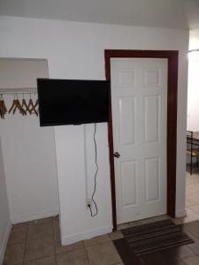 a room with a door and a flat screen tv at Motel Safreen in Panama City Beach