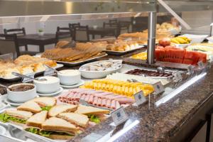 a buffet line with sandwiches and other food items at Centromar Hotel in Balneário Camboriú