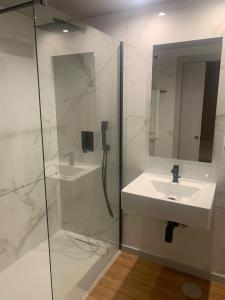 a bathroom with a shower, sink, and mirror at Hotel Vianorte in Maia