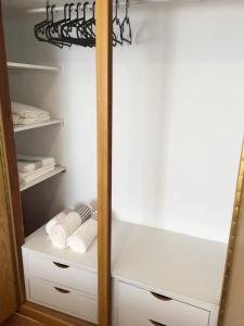 um armário com toalhas brancas e um espelho em LA PLAYA em Retamar