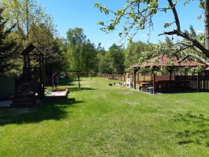 un parque con parque infantil y cenador en Domek nad Krutynią, en Piecki