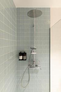 y baño con ducha y azulejos azules. en Casa do Gadanha en Estremoz